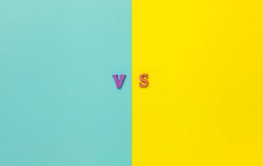 Sarı ve Mavi kağıt arkaplanda fotokopi alanı olan harfler vs. Seçim yapma konsepti. Mektuplara karşı. Sarı ve mavi arkaplan ve ahşap harfler vs.