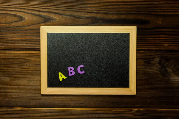 Back to school concept close up wooden colourful alphabet letters ABC on Blackboard
