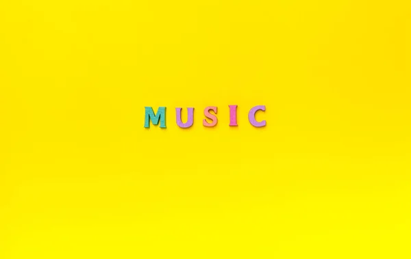 Music Veelkleurige Houten Letters Belettering Woord Een Gele Achtergrond Muziekliefhebber — Stockfoto