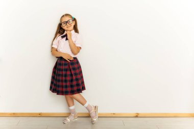 İki kuyruklu, resmi bluzlu, beyaz arka planda kırmızı etekli, tam vücut ölçülerinde bir kız.