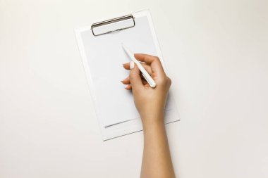 Beyaz a4 kağıt tasarımı modeliyle boş bir panoya el yazısı. Belge sahibini temizle, şablon tutucu kolu oluştur. Kontrol listesi veya sunum için beyaz arkaplan üzerine klip tahtası not defteri.