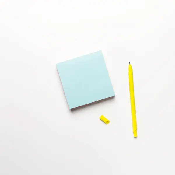 Blank blue sticky note with yellow pen on white background