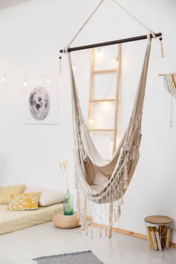 Beyaz oturma odası, alçak yatak ve hamak boho tarzı.