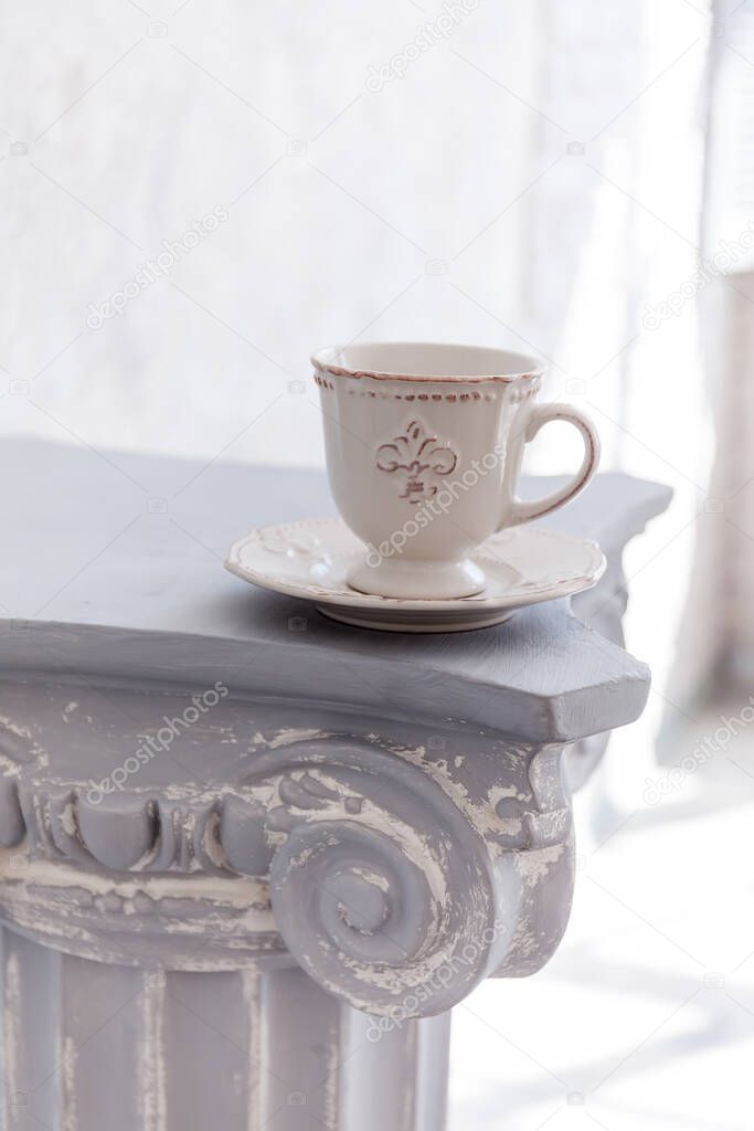 Stone column with an antique lily cup on light gray background. Close-up, copy space, vertical format