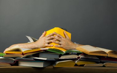 İnsanoğlu 'nu okumaktan yorulmuş renkli bir yığın kitapla dolu, elleri sarı bir kitapla yüzünü kapatmış. Bilgilerin içinde kaybolun. Kopyalama uzayı ile ilgili bir çok bilgi kavramı