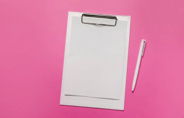 Beyaz kağıt ve pembe arka planda beyaz kalemle dolu bir dosya. Üst görünüm ofis aksesuarları