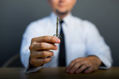 Masadaki iş adamının elinde başarının anahtarı. İş hayatında başarı kavramı