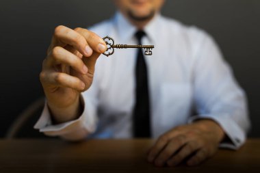 İş başarısı için en iyi tavsiye. Masadaki iş adamının elinde başarının anahtarı. İş hayatında başarı kavramı