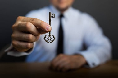 Masadaki iş adamının elinde başarının anahtarı. İş hayatında başarı kavramı