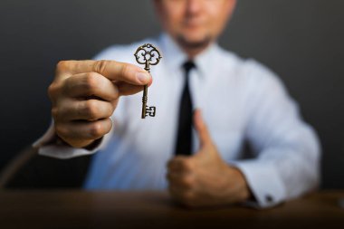 Başarılı bir işe erişim. Masadaki iş adamının elinde başarının anahtarı. İş hayatında başarı kavramı