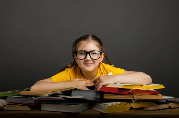 教育と学校のコンセプトに戻る 学校で多くの本を持つ笑顔の小さな学生の女の子 灰色の背景を持つテキストのためのコピースペース — ストック写真