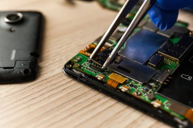 Masadaki tornavidayla cep telefonunu tamir ederken yaklaş. Bilgisayar donanımı, cep telefonu, elektronik, onarım, güncelleme ve teknoloji kavramı.