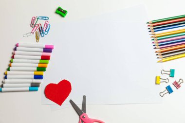 Kağıt, boya kalemi, kalem, makas ve malzemeleri beyaz bir masaya koyun. Çocuk sanatı, çocuklar için zanaat ya da bir çocuğu okula hazırlamak. Yaratıcılık Masaüstü