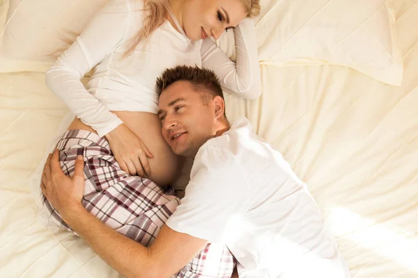 Happy Young Man Listening His Pregnant Wife Belly While Lying — Stock Photo, Image