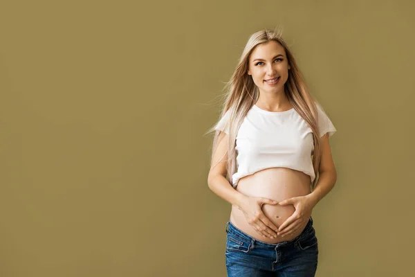 Close Van Zwangere Vrouw Aanraken Van Haar Buik Beige Achtergrond — Stockfoto