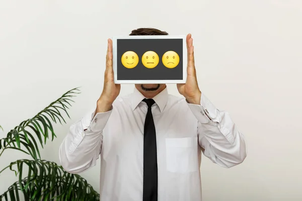 Customer service concept, businessman holding digital tablet with emoticons and rating for his satisfaction
