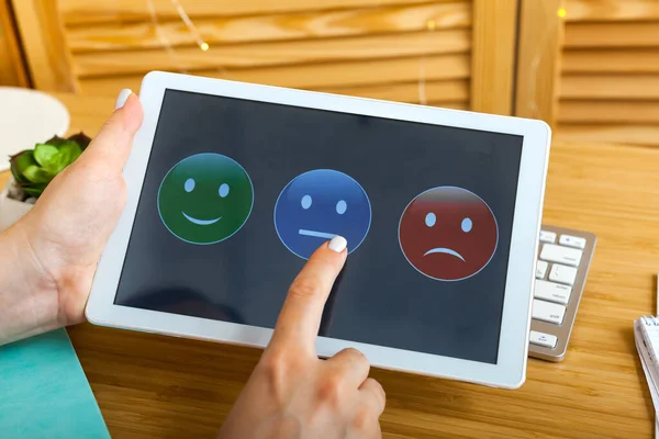 Survey, poll or questionnaire for user experience or customer satisfaction research. Quality control and feedback concept. Woman choosing his opinion with smiley faces on touch screen.