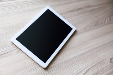 Eski ahşap arka planda ipad mini gibi görünen beyaz tablet.