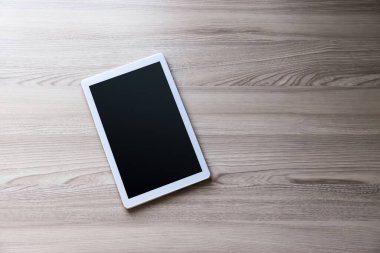 Eski ahşap arka planda ipad mini gibi görünen beyaz tablet.
