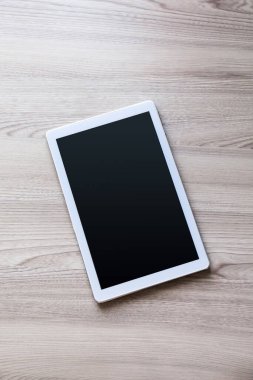 Eski ahşap arka planda ipad mini gibi görünen beyaz tablet.