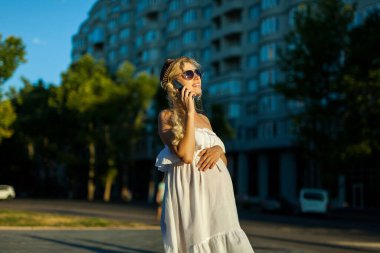 Hamilelik, teknoloji, insanlar ve iletişim konsepti mutlu hamile beyaz kadın şehirdeki Streen 'de akıllı telefondan arıyor.
