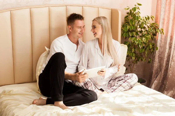 Hamile Bir Kadın Bir Erkek Evdeki Yatakta Uzanıyorlar Beyaz Tabletlerine — Stok fotoğraf