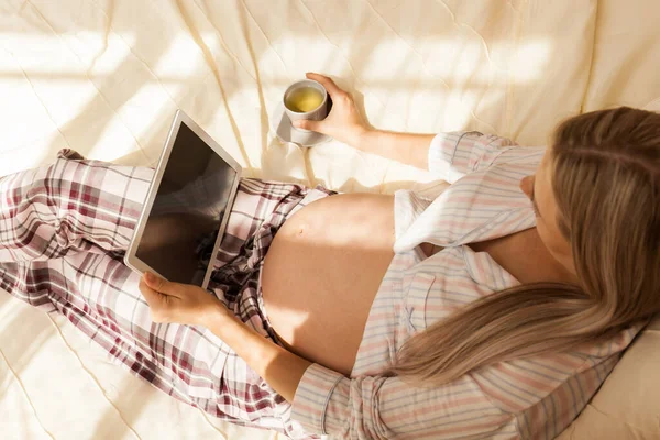 침대에 누워서 타블렛을 임산부의 사진입니다 임신중 온라인 쇼핑과 기술의 — 스톡 사진