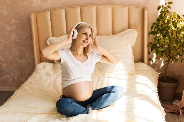 Mulher Grávida Bonita Sentada Cama Posição Lótus Casa Ouvir Música — Fotografia de Stock