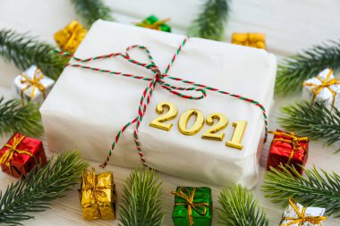 Noel hediyesi ve ahşap arka planda Mutlu Yeni Yıl 2021. El yapımı Noel kutusu, köknar dalları, el işi kağıt, üst görünüm..