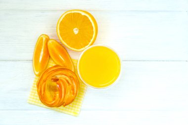 Turuncu pasta ve portakal suyu ve portakal dilimleri ve beyaz ahşap arka planda takozlar..