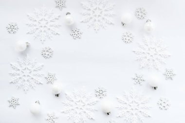 Noel ya da kış geçmişi. Beyaz arka planda beyaz toplar ve kar tanelerinden oluşan desen. Noel, kış, yeni yıl konsepti. Düz konum, üst görünüm, kopyalama alanı