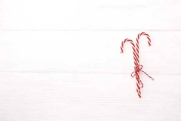 圣诞糖果手杖 带条纹的绳索弓 白色木制桌子背景 精美的圣诞贺卡 有影印空间 — 图库照片
