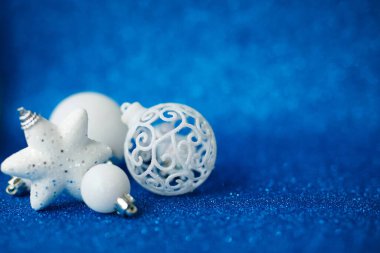 Beyaz Noel baloları ve yıldız, parlak mavi arka plan süslemesi