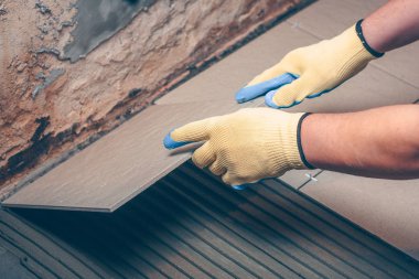 İşçi kare karoyu dikkatlice yere koyar.