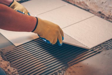 İşçi profesyonel banyo döşeme, zemin döşeme koyar