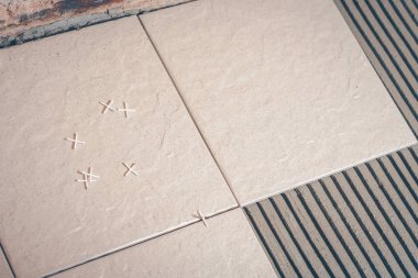 Yerdeki fayans döşeme için plastik haçlar kutunun üzerinde dağılmış