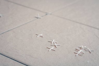 Yerdeki fayans döşeme için plastik haçlar kutunun üzerinde dağılmış