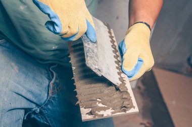 Kiremitçi bir mala kutunun arkasına doğru bir spatula ile geçerlidir