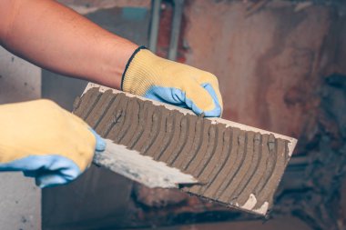 Kiremitçi bir mala kutunun arkasına doğru bir spatula ile geçerlidir