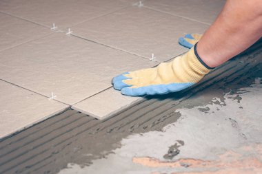 İşçi profesyonel banyo döşeme, zemin döşeme koyar