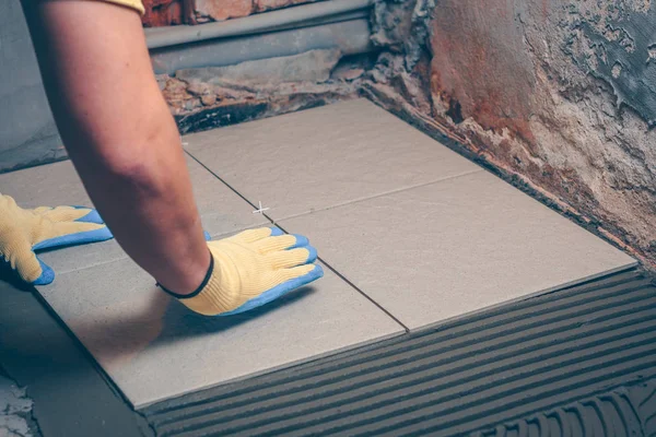 Çini karo yere çentikli bir mala tarafından uygulanan bir yapıştırıcı ile ahşaba yapıştıran bir ürüne