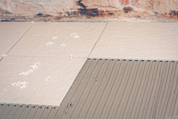 Yerdeki fayans döşeme için plastik haçlar kutunun üzerinde dağılmış