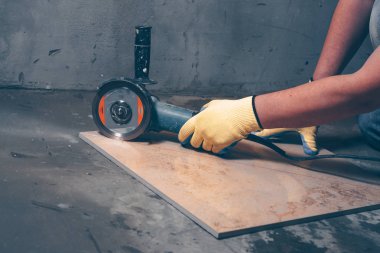 Eldiven işçi fayans porselen stoneware kesmek için açı öğütücü kullanır