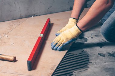 İşçi eldiven eller iş evde, çok yetenekli iş bitirme yere, kiremit tuşuna basın.