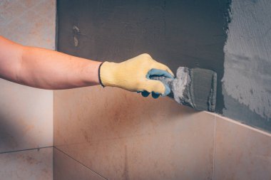 Çalışma kiremitçi tutkal duvarda bir spatula ile yapıştırma önce döşeme ve kaplama teknolojisi geçerlidir