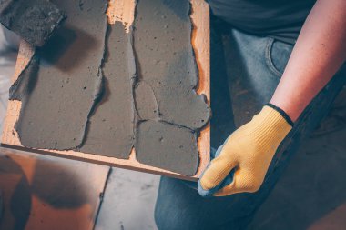 Çalışma kiremitçi tutkal kutunun üzerinde çentikli bir mala ile yapıştırma önce döşeme ve kaplama teknolojisi geçerlidir