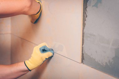 Çalışan tiler kiremit montaj için plastik haçlar kullanır