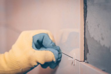 Çalışan tiler kiremit montaj için plastik haçlar kullanır