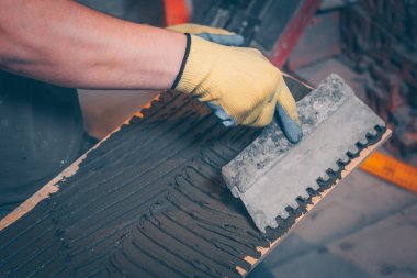 Çalışma kiremitçi tutkal kutunun üzerinde çentikli bir mala ile yapıştırma önce döşeme ve kaplama teknolojisi geçerlidir