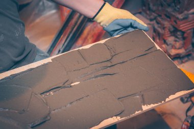 Çalışma kiremitçi tutkal kutunun üzerinde çentikli bir mala ile yapıştırma önce döşeme ve kaplama teknolojisi geçerlidir